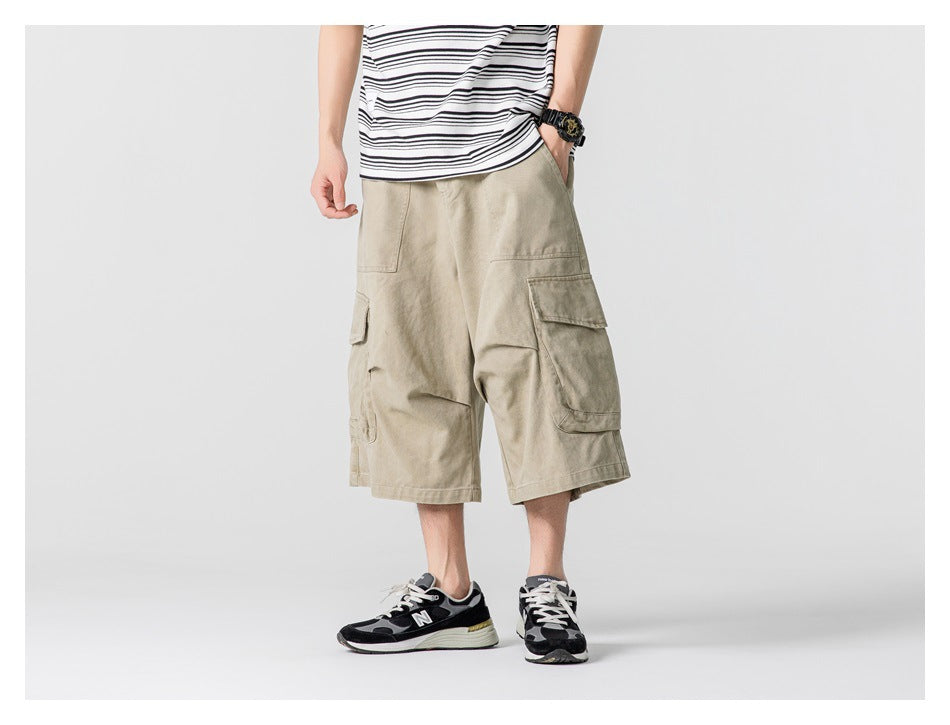 Front view of a model wearing beige knee-length cargo shorts with large flap pockets.