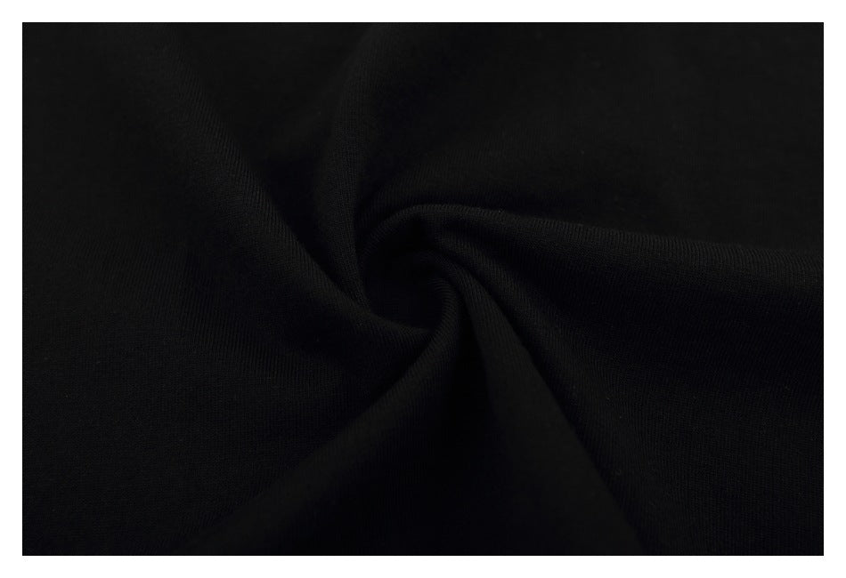 Close-up of black fabric arranged in soft folds, showing a subtle fine texture.