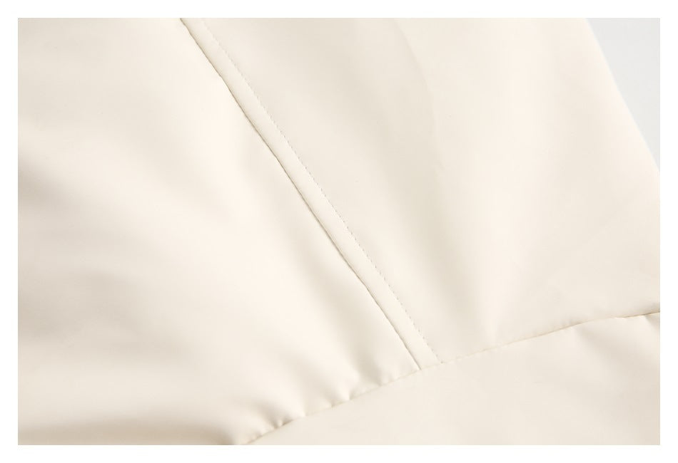 Close-up of cream fabric showing a diagonal stitched seam and a curved panel seam.