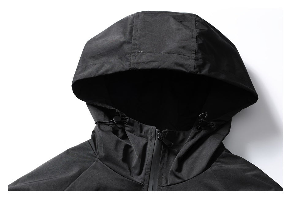 Close-up of a black jacket’s hood, adjustable drawcords, and upper zipper.