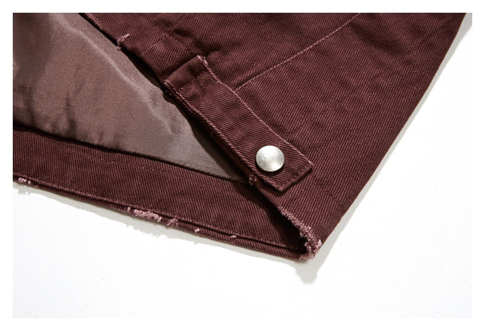 Close-up of a burgundy jacket opening with a silver snap tab and a glimpse of the lining.