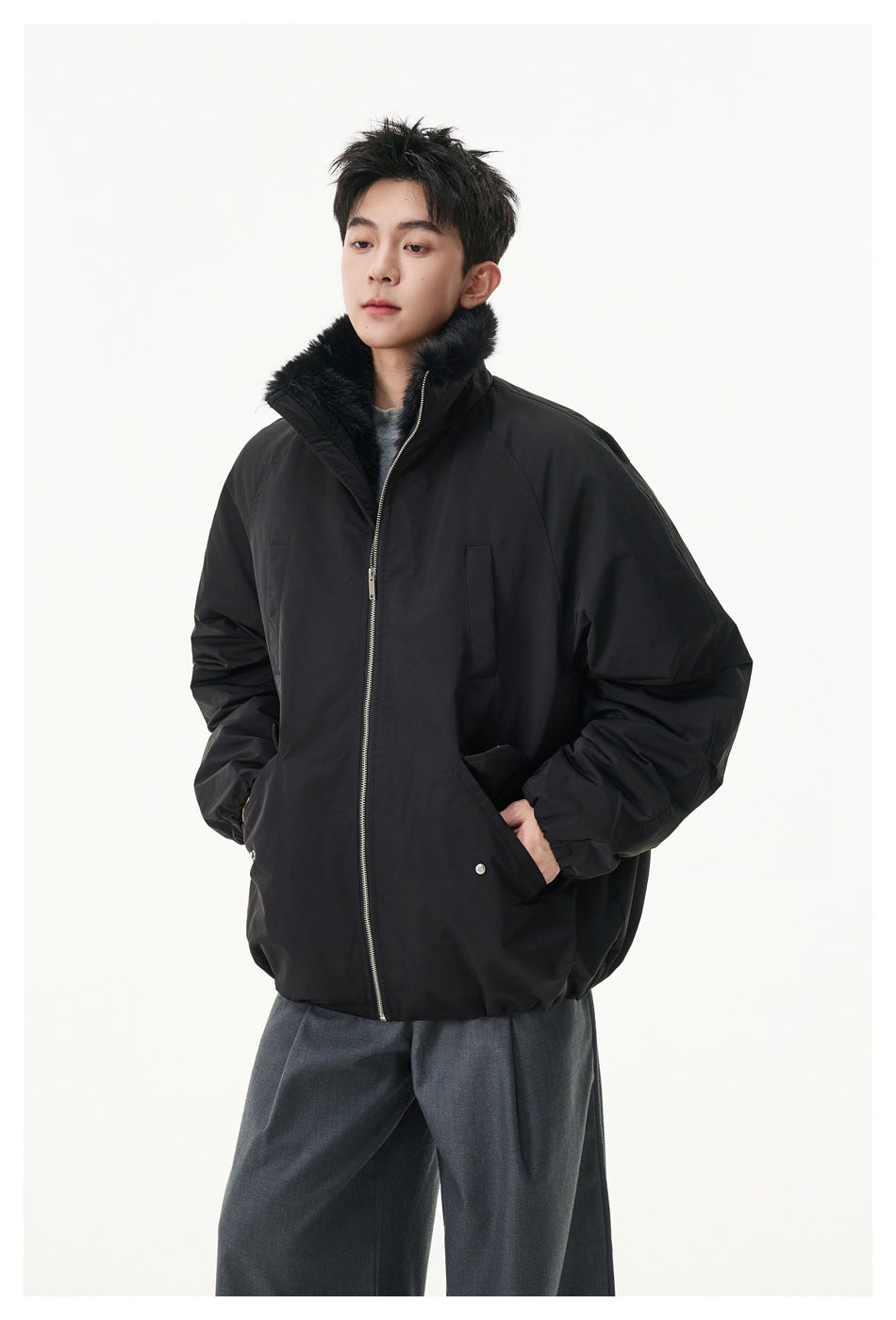 Front view of a model wearing a black oversized zip jacket with a plush black collar.