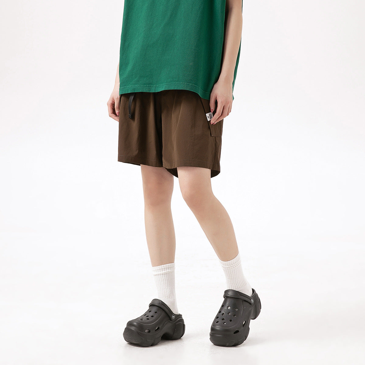 Model wearing brown knee-length shorts with a drawstring waist and side pocket.
