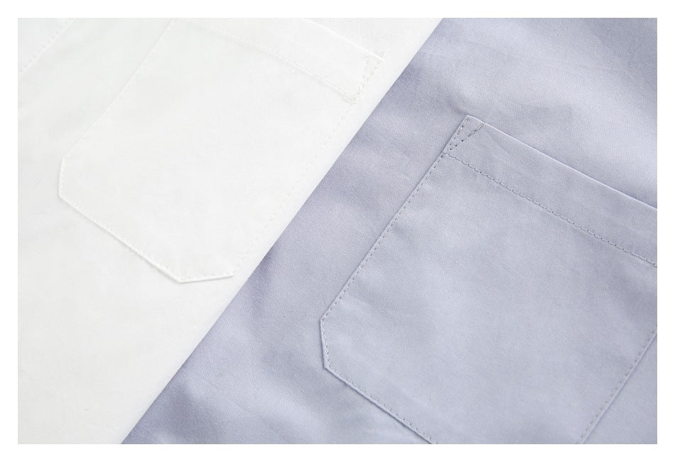 Close-up of white and pale lavender shirt fabrics with matching angled-corner chest pockets and stitching.