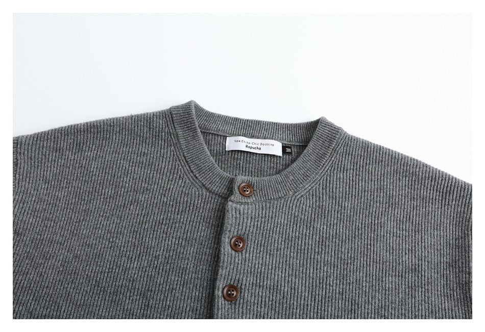 Close-up of the gray cardigan's ribbed crew neck, three brown buttons, and sewn-in neck label.