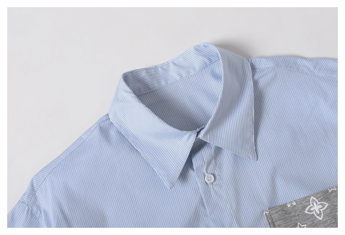 Close-up of a light blue striped shirt collar and shoulder, with part of a gray printed pocket visible.