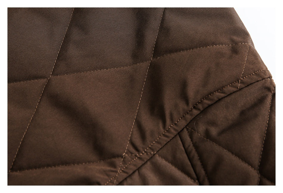Close-up of dark brown quilted jacket panels and curved stitched seams.