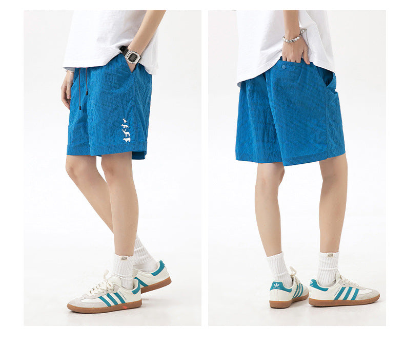 Model shown from side and back wearing bright blue drawstring shorts with a white leg graphic.