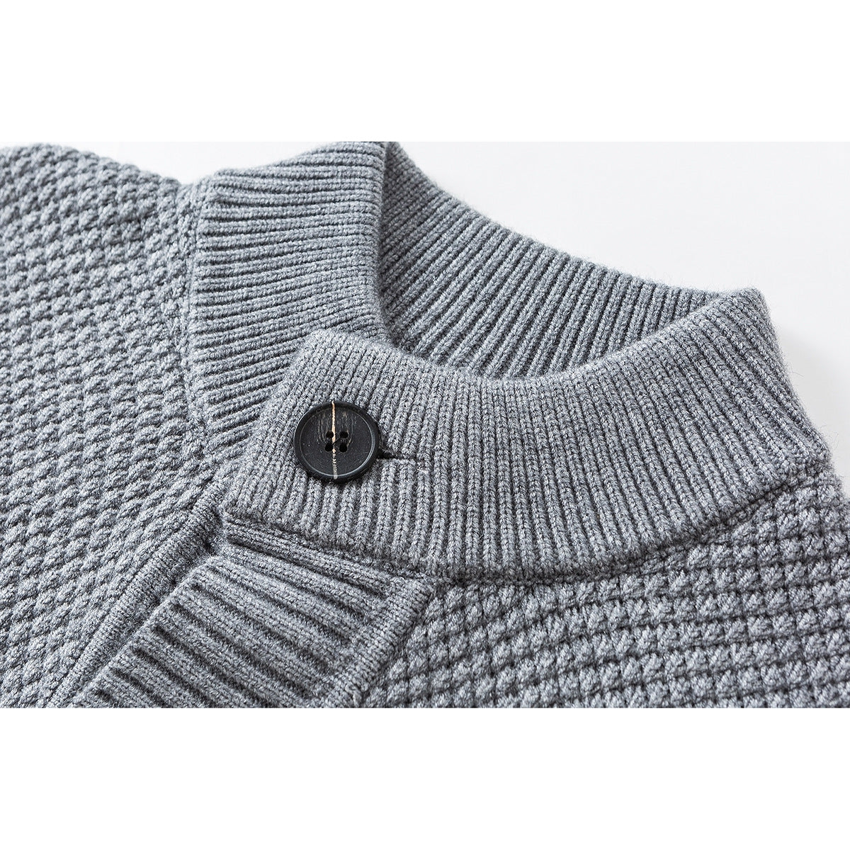 Close-up of a gray textured knit cardigan's ribbed stand collar and dark button.