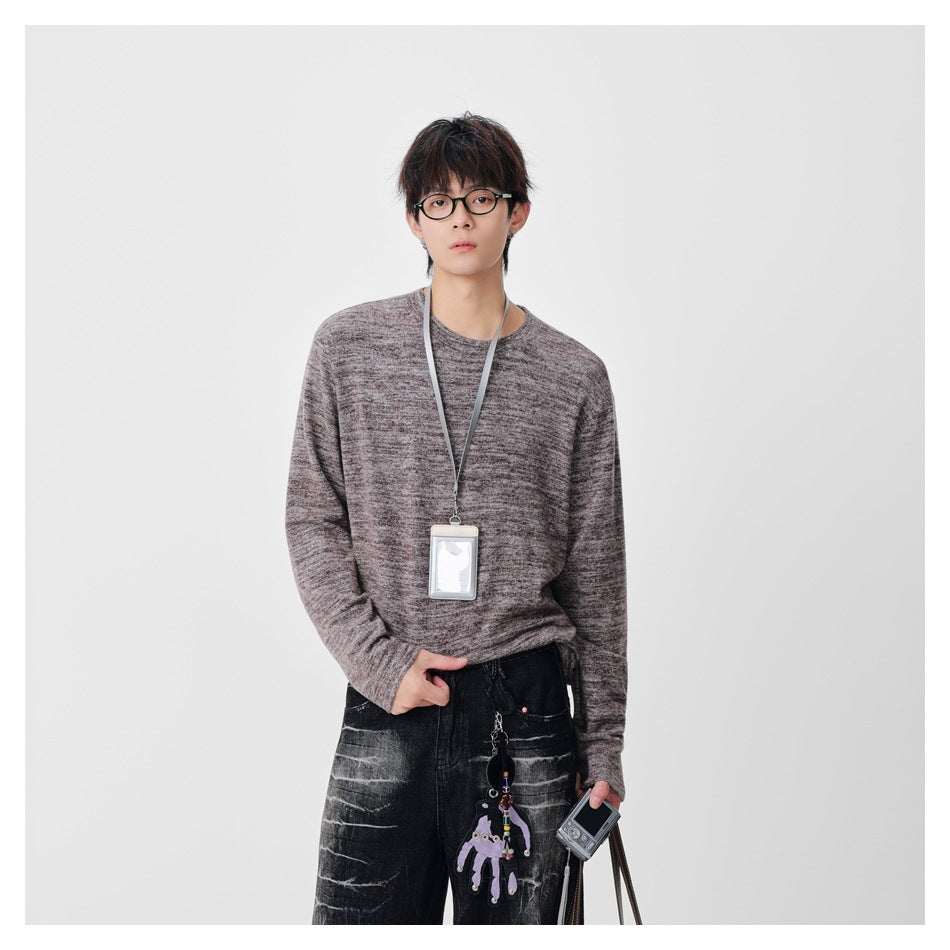 Closer front view of a model wearing a mottled taupe-gray long-sleeve crewneck sweater.