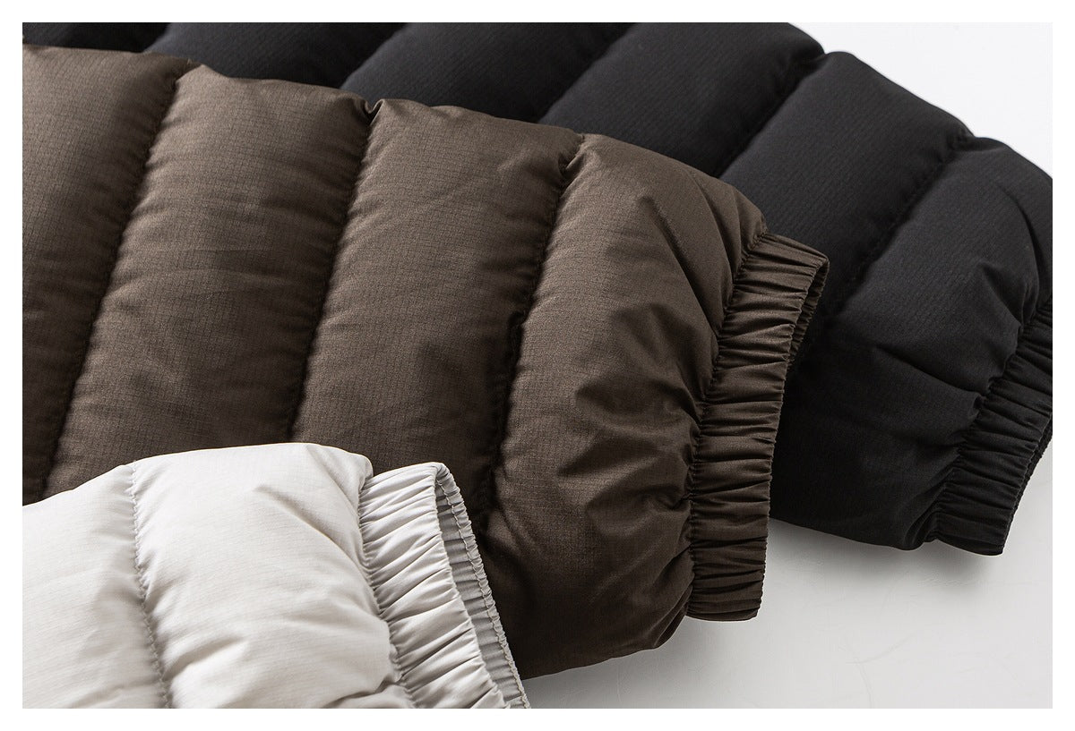Close-up of padded jacket cuffs in white, brown, and black, showing gathered elastic edges.