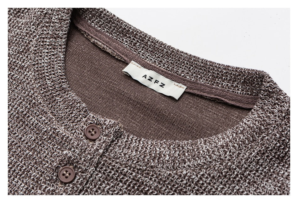 Close-up of a taupe marled knit cardigan neckline, two buttons, and sewn neck label.