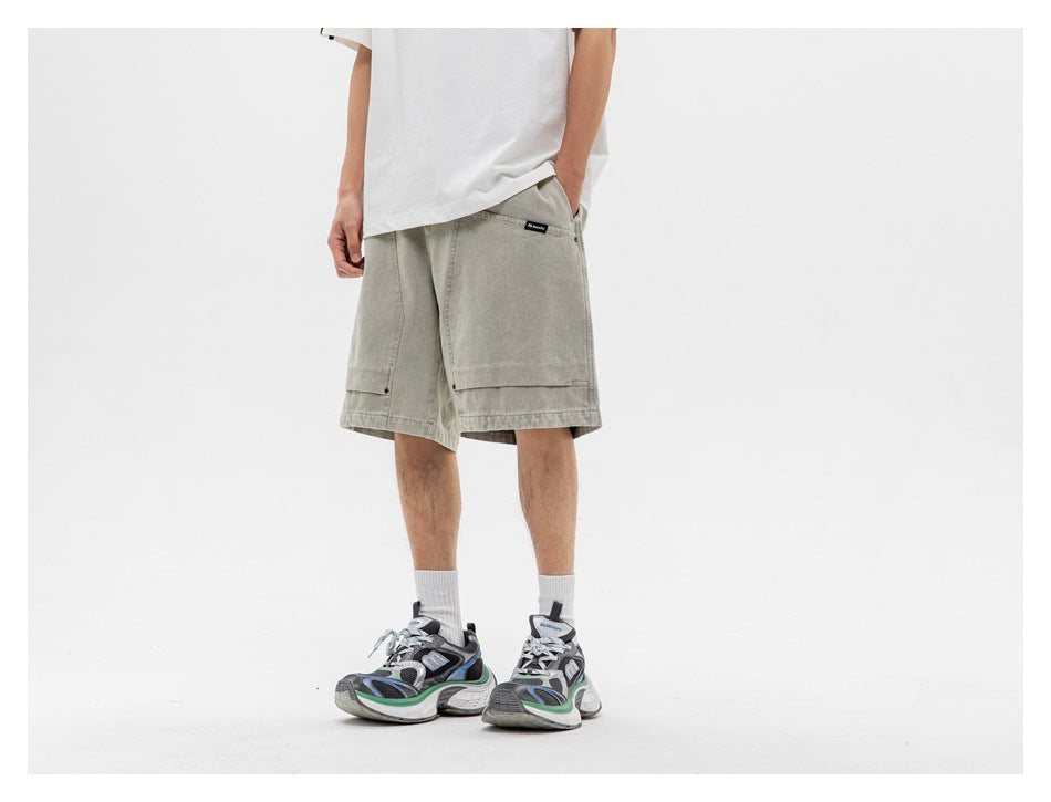 Model wearing loose light gray-green shorts with large front patch pockets and a white T-shirt.