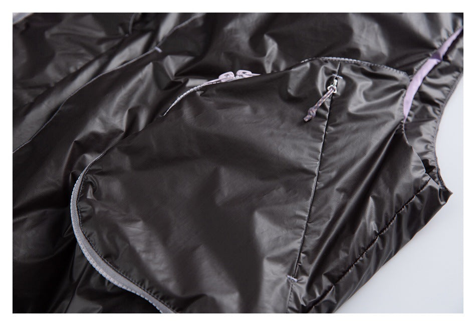 Close-up of a black jacket pocket with a curved edge, pale zipper trim, and cord pull.