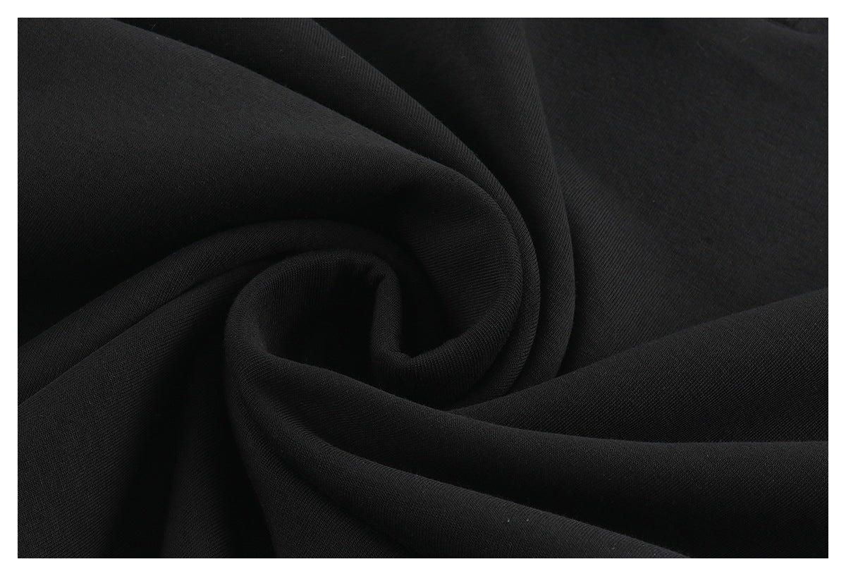 Close-up of black fabric gathered into a spiral, showing its fine surface texture.