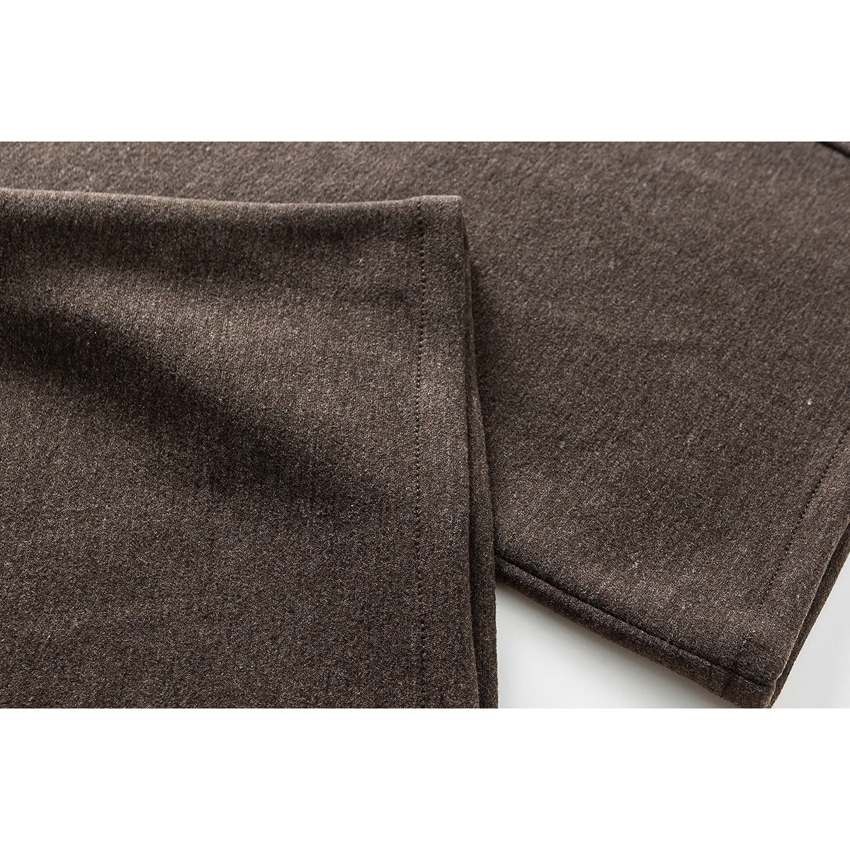 Close-up of brown pants fabric and stitched hems.