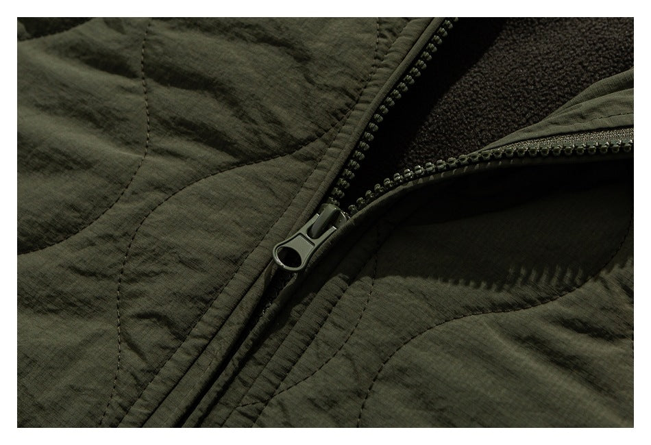 Close-up of an olive-green jacket with its front zipper partly open, showing dark textured lining.