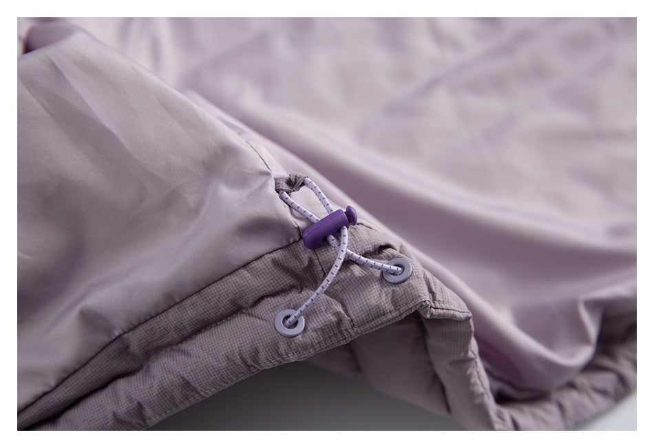 Close-up of a pale mauve jacket hem with a purple cord lock and adjustable drawcord.