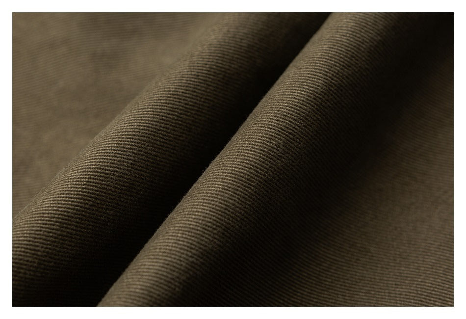 Macro view of olive-brown fabric draped into folds, showing its woven surface texture.