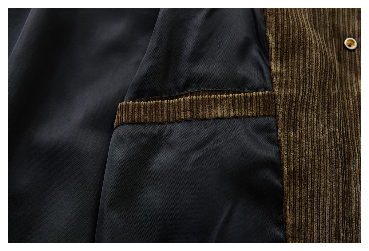 Close-up of a brown corduroy jacket showing its dark lining, seam, and snap button.