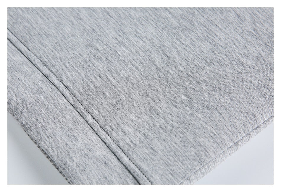 Close-up of heather gray fabric showing a diagonal stitched seam and finished edge.