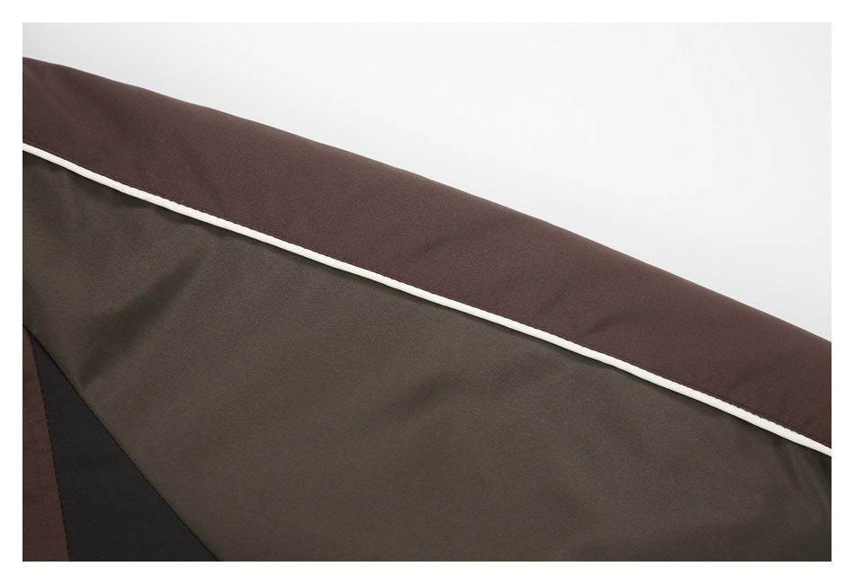 Close-up of the jacket's olive sleeve panel, brown fabric, and white piping.