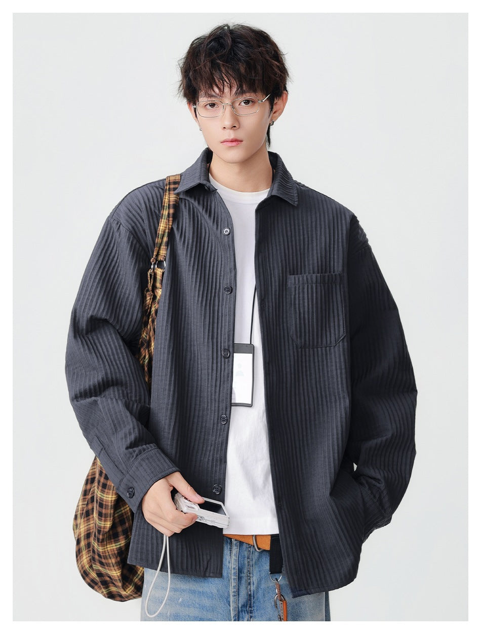 Front view of a model wearing an oversized charcoal ribbed button-up shirt with a single chest pocket.