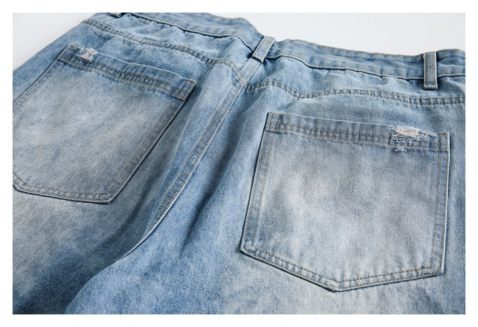 Rear view of light blue jeans laid flat, showing two back pockets and belt loops.