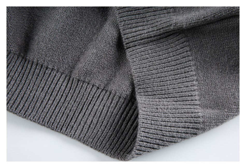 Close-up of the charcoal gray cardigan’s wide ribbed hem and folded knit edge.