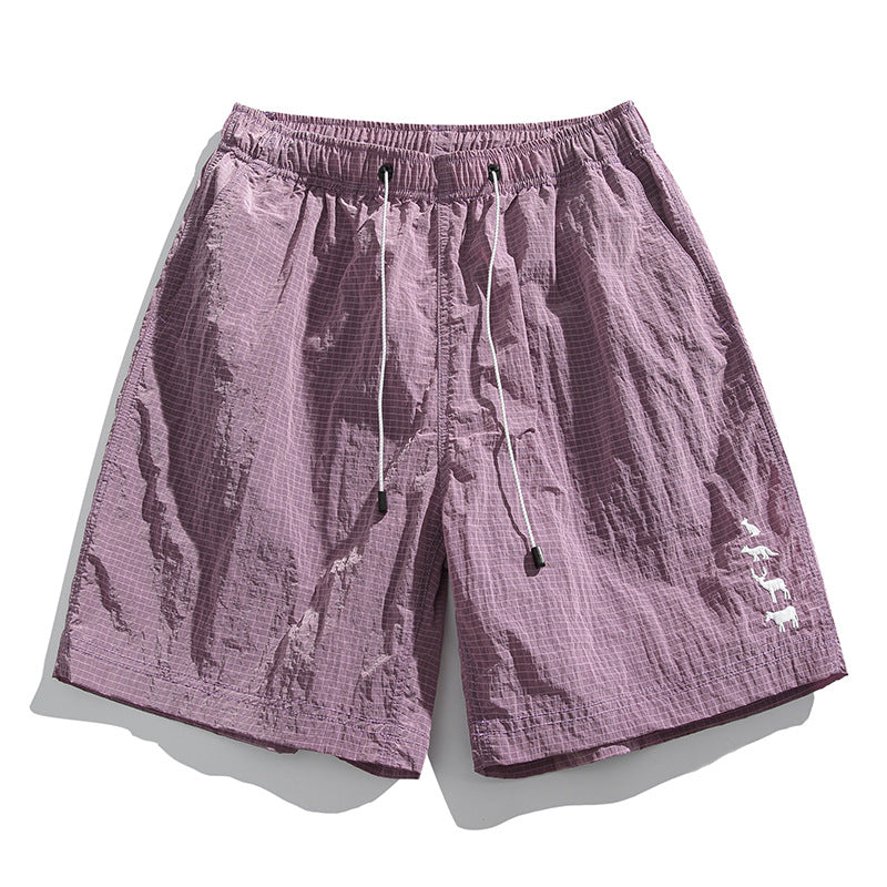 Dusty mauve-pink textured drawstring shorts with grid pattern and white animal embroidery, flat lay