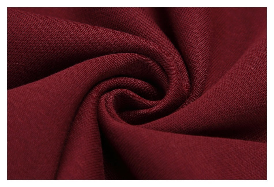 Close-up of burgundy fabric gathered into a spiral, showing its fine knit texture.