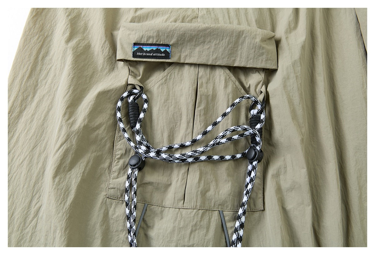 Close-up of a khaki flap pocket and black-and-white cord loops with round toggles.