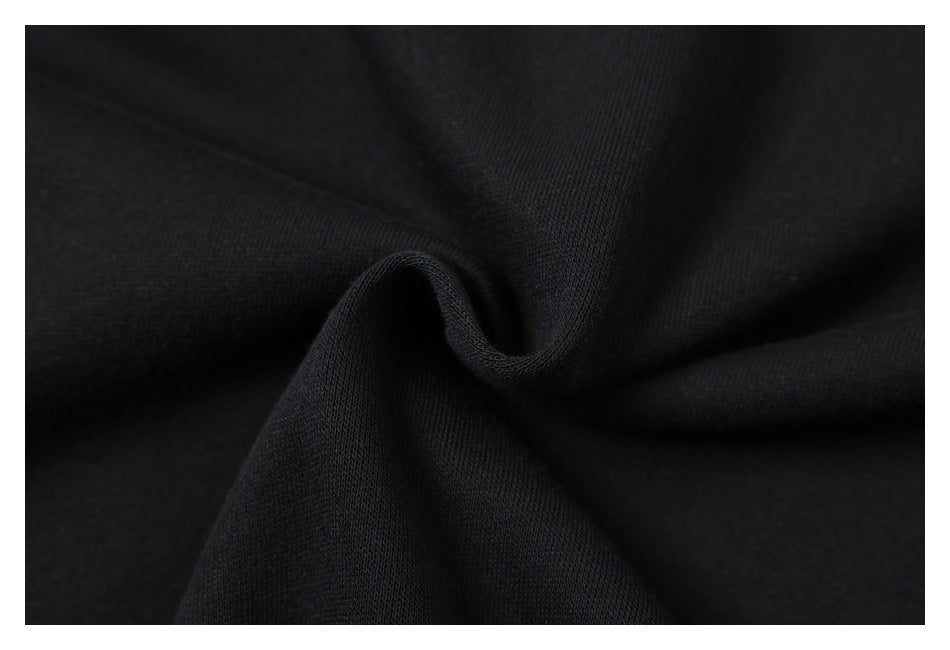 Close-up of black fabric gathered into a soft fold, showing its surface texture.