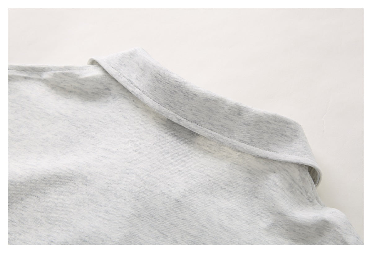 Close-up of the light gray heather polo shirt’s folded collar and neckline.