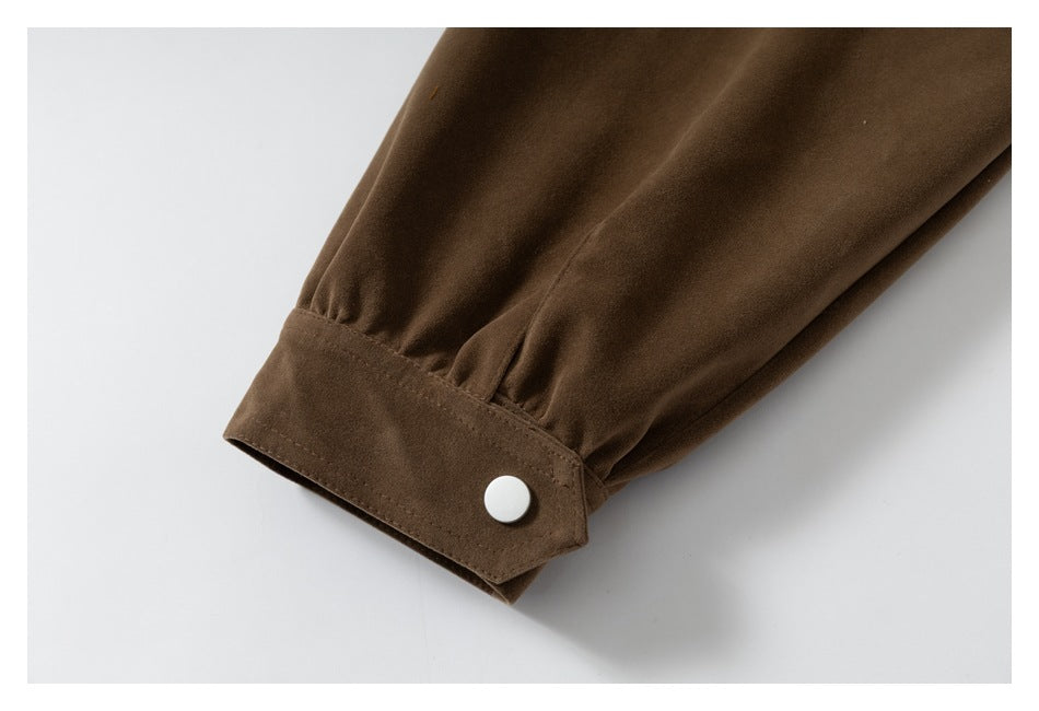 Close-up of a brown sleeve cuff with a light-colored snap button.