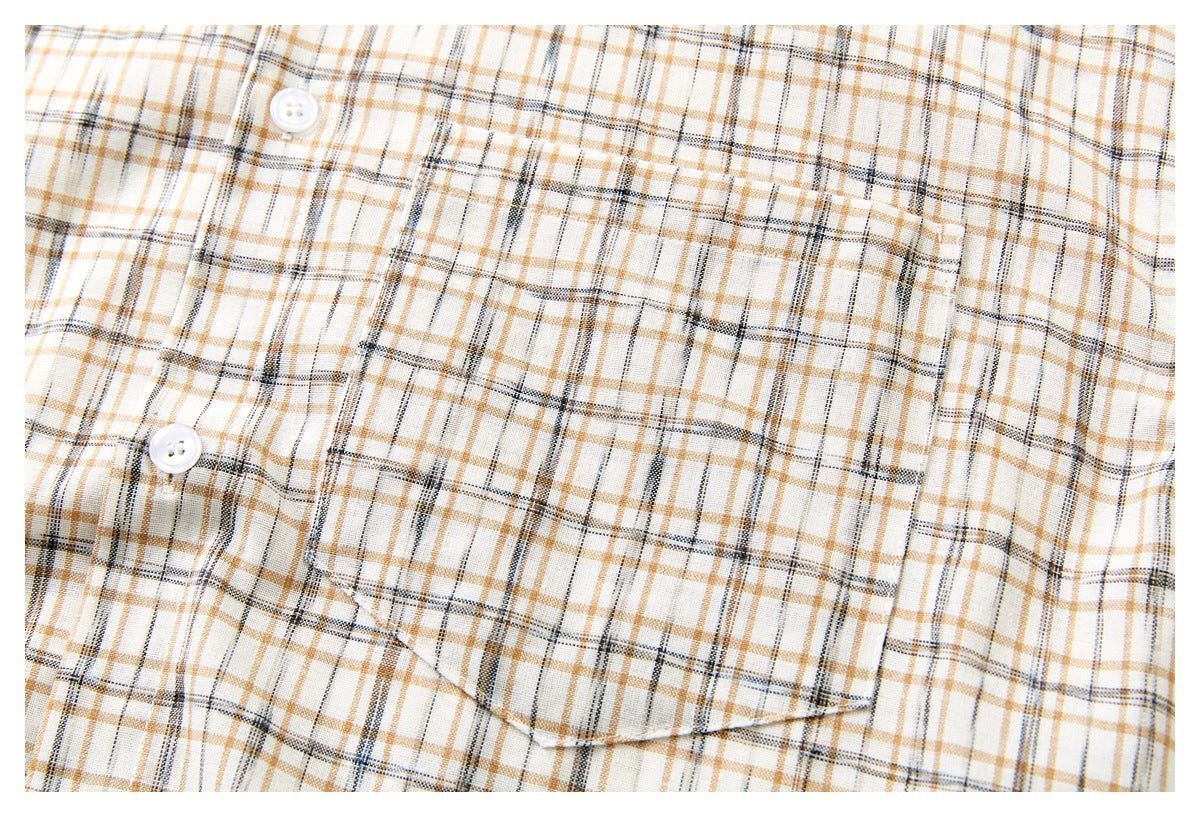 Close-up of a cream plaid shirt front showing a button and a single chest pocket.
