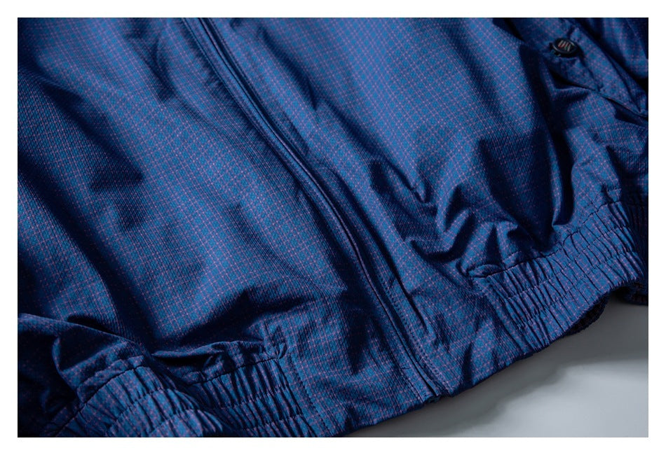 Close-up of a blue-and-purple patterned jacket's front zipper and gathered elastic hem.