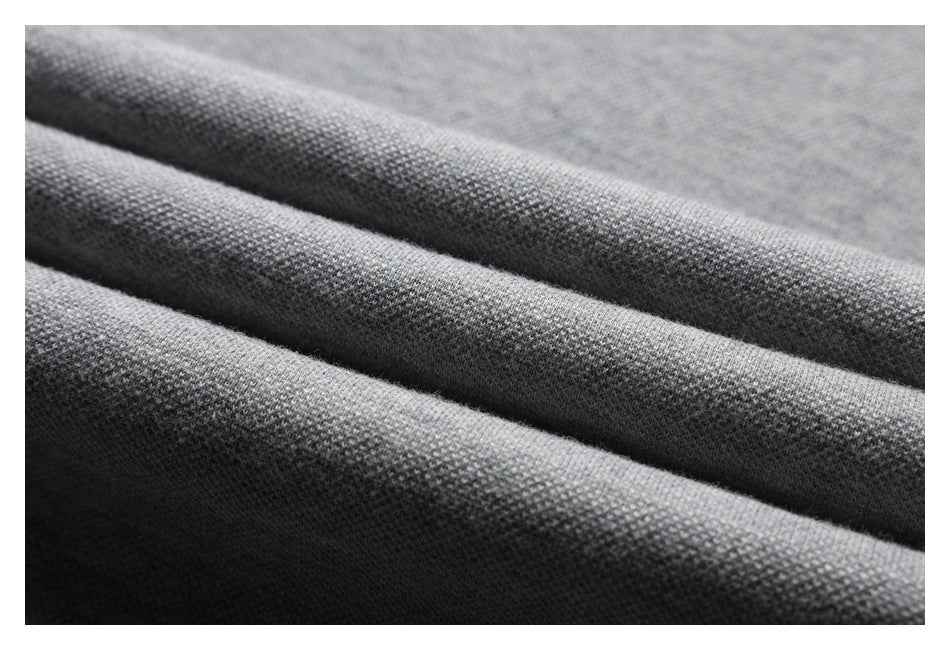 Close-up of gray knit fabric arranged in parallel folds, showing its fine textured surface.