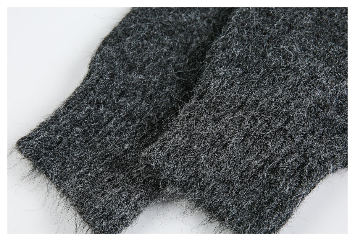 Close-up of overlapping edges of a charcoal gray fuzzy knit garment.