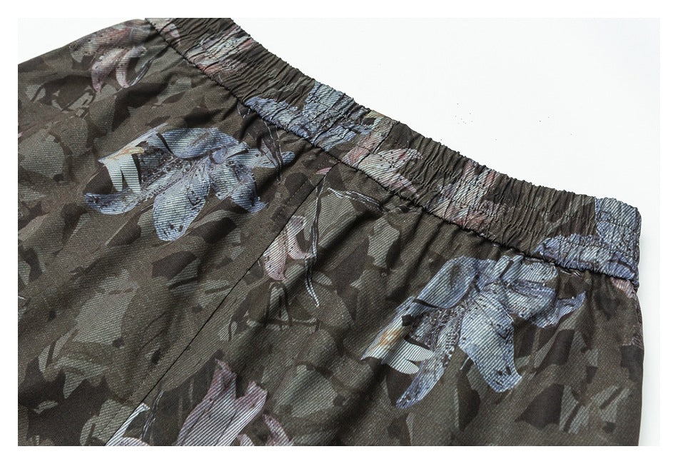 Close-up of the gathered waistband and printed upper section of dark camouflage pants.
