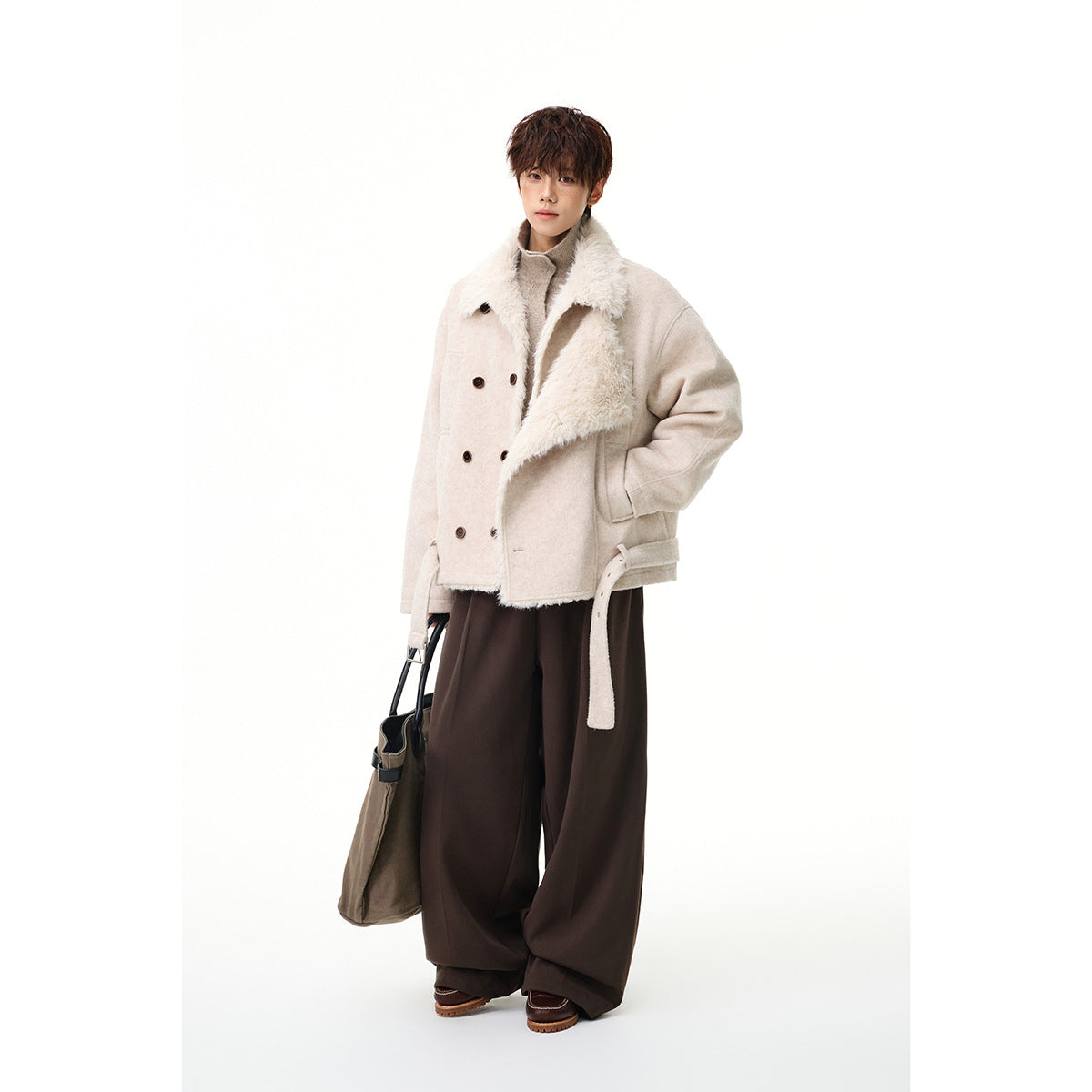Full-length model wearing a cream jacket with a fluffy asymmetric lapel, paired with wide dark trousers.