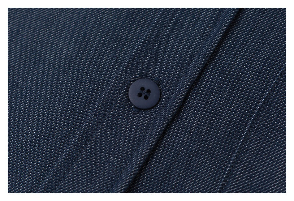 Close-up of a dark four-hole button on textured navy fabric.