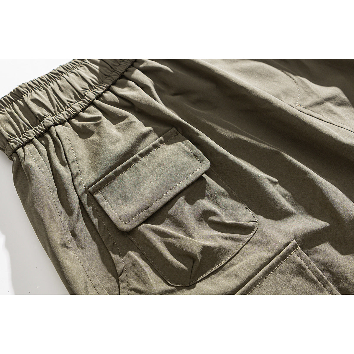 Close-up of khaki cargo shorts showing an elastic waistband and a large flap pocket.