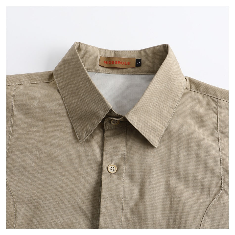 Close-up of the beige micro-check shirt's pointed collar, buttons, and neck label.