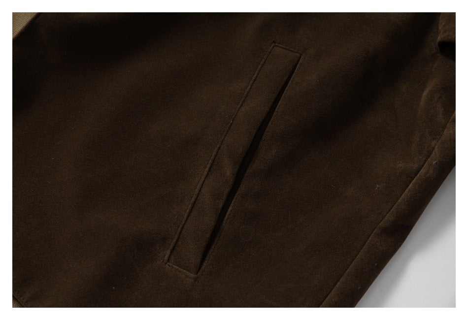 Close-up of a dark brown garment showing a narrow vertical welt pocket.
