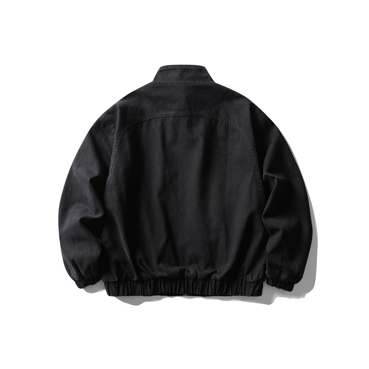 Back view of a black jacket with a stand collar and gathered elastic hem and cuffs.
