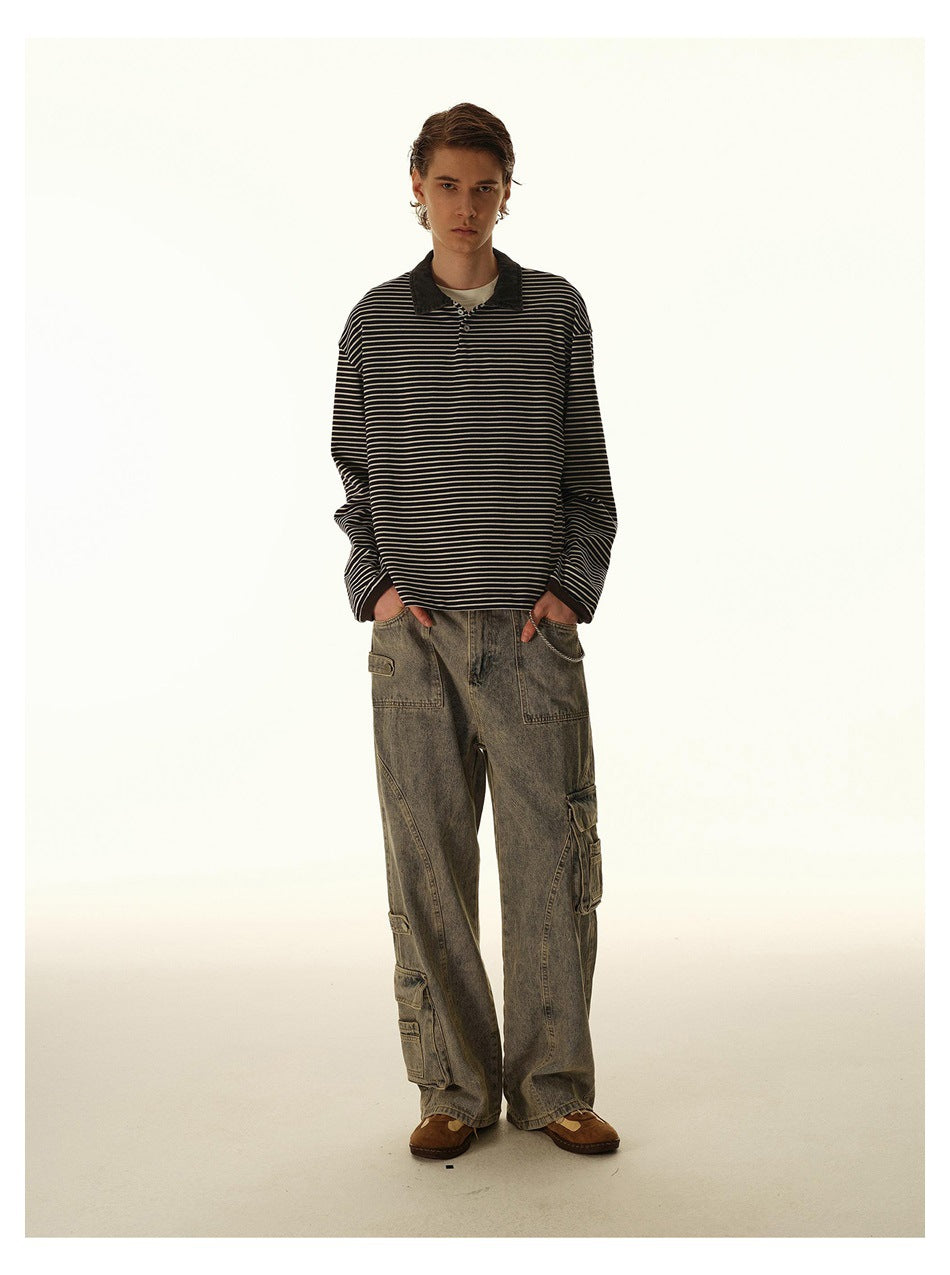 Model wearing gray washed wide-leg cargo jeans with multiple utility pockets and a black-and-cream striped long-sleeve polo.