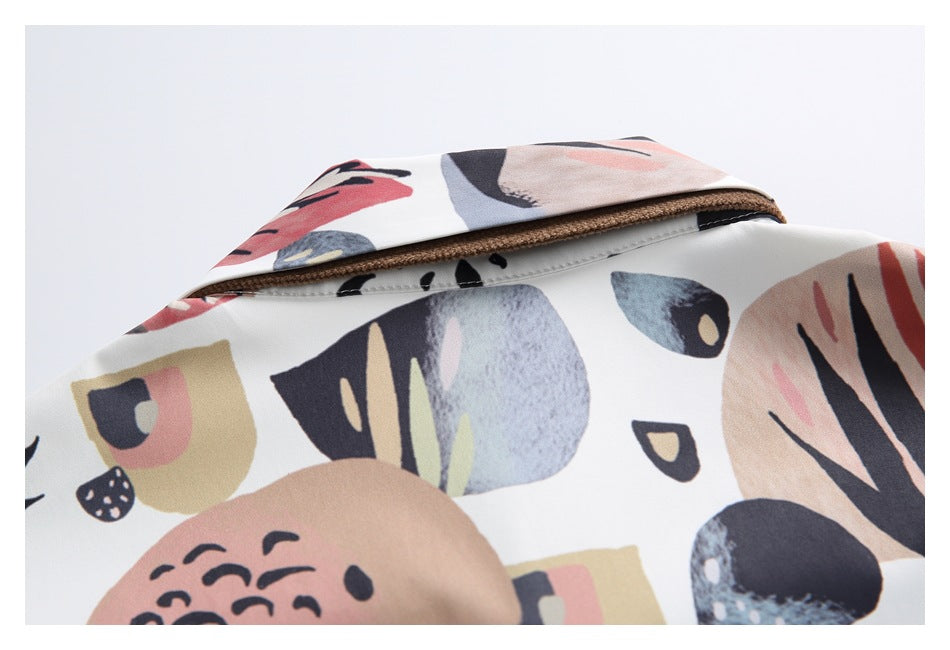 Close-up of the folded collar on a white garment with abstract multicolor print.