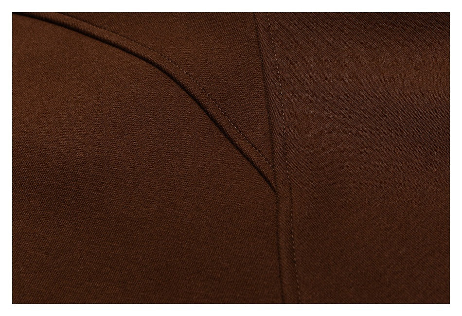 Close-up of curved stitching and a seam on dark brown fabric.