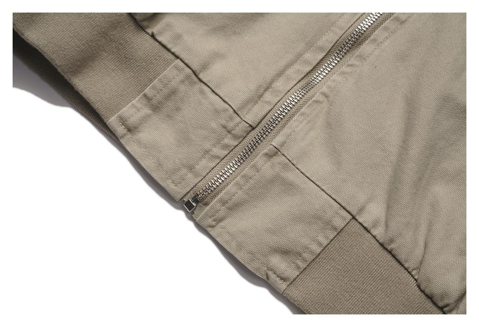 Close-up of the jacket’s silver zipper, stitching, and ribbed hem.